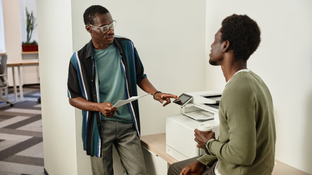 Two people standing at a printer